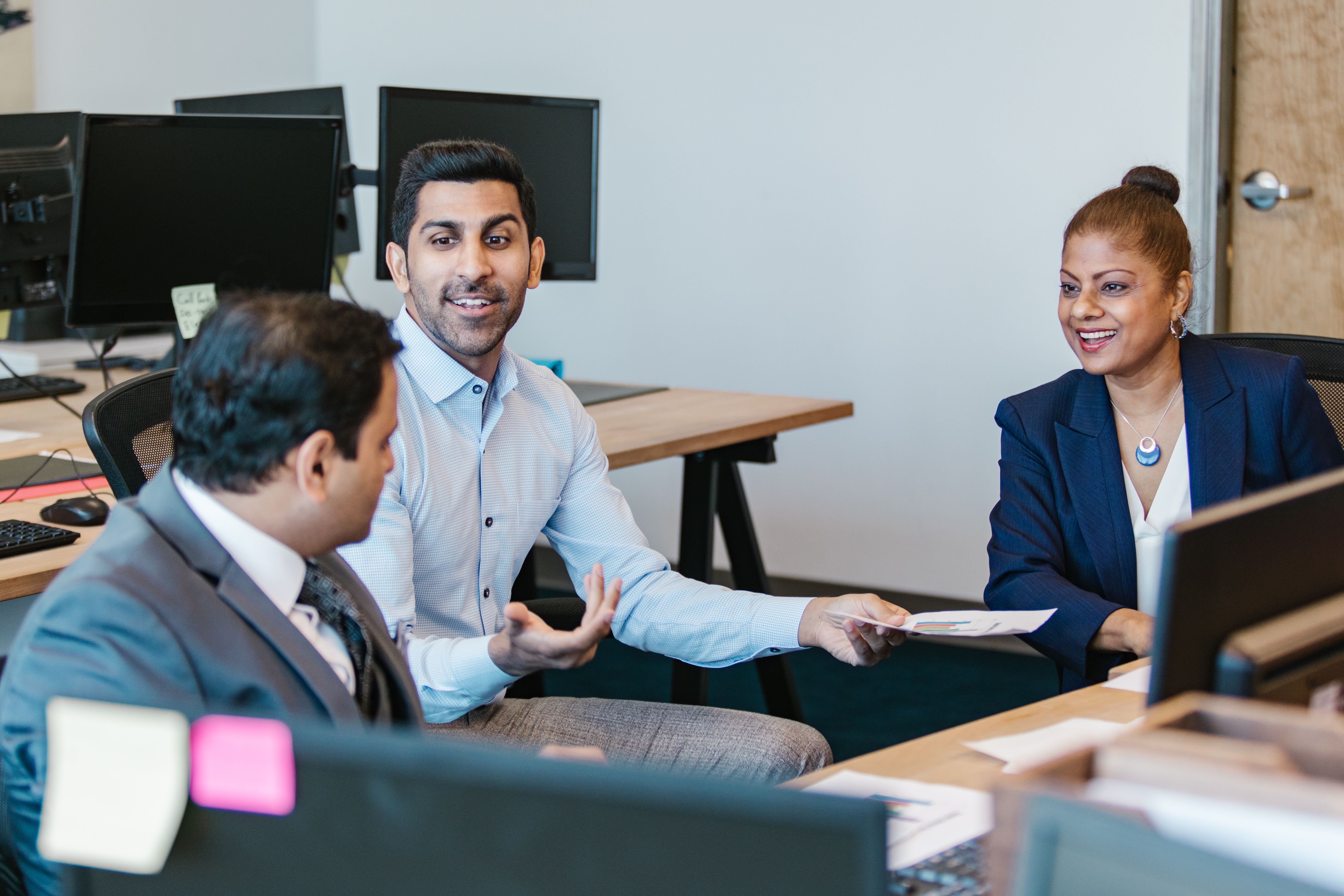 Two colleagues planning an event together over a laptop and notes